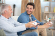 © auremar - mature man playing video game with his son at home