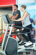 © auremar - man and woman using step machines in fitness center