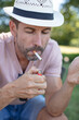 © auremar - young man sits on a park bench with a cigarette