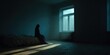 © Aleksandr - A depressed or thoughtful woman sitting alone on the edge of a bed in a minimalist dark room with morning light coming through a large window.