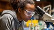 © possawat - Female Scientist Observing Sample Through Microscope in Laboratory