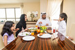 © oneinchpunch - Arab family wearing traditional emirati clothing bonding at home in Dubai