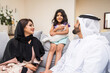 © oneinchpunch - Arab family wearing traditional emirati clothing bonding at home in Dubai
