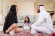 © oneinchpunch - Arab family wearing traditional emirati clothing bonding at home in Dubai
