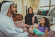 © oneinchpunch - Arab family wearing traditional emirati clothing bonding at home in Dubai