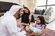 © oneinchpunch - Arab family wearing traditional emirati clothing bonding at home in Dubai