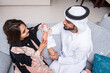 © oneinchpunch - Arab married couple wearing traditional emirati clothing at home - Middle eastern man and woman spending time together, domestic life in a traditional middle east family