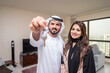 © oneinchpunch - Arab married couple wearing traditional emirati clothing at home - Middle eastern man and woman spending time together, domestic life in a traditional middle east family