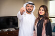 © oneinchpunch - Arab married couple wearing traditional emirati clothing at home - Middle eastern man and woman spending time together, domestic life in a traditional middle east family