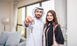 © oneinchpunch - Arab married couple wearing traditional emirati clothing at home - Middle eastern man and woman spending time together, domestic life in a traditional middle east family