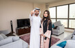 © oneinchpunch - Arab married couple wearing traditional emirati clothing at home - Middle eastern man and woman spending time together, domestic life in a traditional middle east family