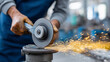© Kateryna Arkhypova - Faceless metalworker sharpening a cold chisel on a pedestal grinder, protective goggles worn, sparks flying sideways, defocused metal workshop behind, metalwork chisel sharpening,