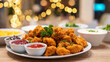 © Bonsales - Crispy fried chicken bites with dipping sauces on a table during a festive meal, enjoying a party feast