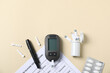 © New Africa - Diabetes. Digital glucometer with test strip, pen, lancets, pills and record form on beige background, flat lay. Space for text