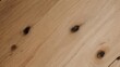 © Via - Close-up view of a light-colored wooden surface with dark knots and grain details