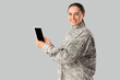 © Pixel-Shot - Female soldier with tablet computer on light background