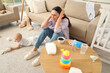© Pixel-Shot - Young mother with her baby suffering from postnatal depression on carpet at home