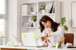 © Pixel-Shot - Busy young businesswoman with laptop, sticky notes and crumpled paper checking time while talking by telephone at her workspace in office. Deadline concept