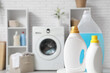© Pixel-Shot - Bottles of detergent on table in light laundry room, closeup