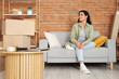 © Pixel-Shot - Beautiful woman sitting in room on moving day
