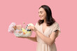 © Pixel-Shot - Beautiful young woman holding Easter basket with different cosmetic products on pink background