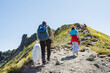 © Elena Medoks - Family hiking in the italian alps with their dog on a sunny day