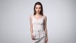 © jadid - Young fashion model showcasing elegant casual outfit with a light top and trousers against a gray backdrop