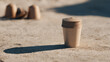 © lemonmoon - Compostable coffee capsule pod stack on sandy outdoor surface with natural sunlight, eco friendly biodegradable material, sustainable alternative for single use coffee brewing