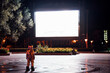 © Westend61 - Spaceman on a square at night attracted by shining projection screen