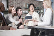 © Westend61 - Happy woman showing tablet to friends with champagne glasses at home