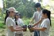 © Wanda - Asian people holding seedlings stand in a circle