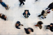 © Westend61 - Commuter woman with backpack standing still amid rushing crowd overhead