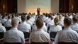 © Olga Ко - Back view of medical professionals in white coats listening to a speaker at a healthcare conference. Group of doctors and scientists attending a seminar in a large auditorium.