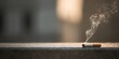 © Studio Nova - The cigarette burning on a concrete ledge with curling smoke and blurred background