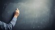 © graphiczone872 - Person writing on blackboard with chalk, empty classroom background, education concept