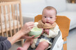 © leungchopan - Mother feeding newborn baby soft mash food at home