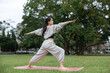 © leungchopan - Healthy woman enjoying yoga training at park