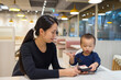 © leungchopan - Mother feeding baby at restaurant during meal time