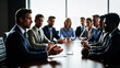 © P.W-PHOTO-FILMS - A businessman gestures while colleagues listen intently during a boardroom meeting. They wear professional attire.