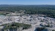 © AmazingAerialAgency - Aerial view of a quarry's stark, jagged landscape contrasting with the soft, green forest, capturing the industrial heart amid nature's embrace, Huntsville, Alabama, United States.