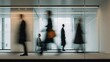 © hariyanti - Blurred figures of business people walking in a modern office hallway.