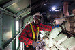 © arrowsmith2 - Confident African Mechanical Engineer Smiling while Maintaining Industrial Engine
