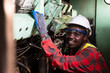 © arrowsmith2 - Cheerful African Mechanic Enjoying Maintenance Work on Industrial Engine