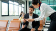© Chaiphorn - Business traveler showing passport to airline staff while sitting in airport lounge waiting area. Concept of airport passenger service air travel process, and international business travel.