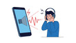 © Prime Visionn - Young man covers his ears in pain while wearing headphones due to loud sound waves coming from a large smartphone screen.