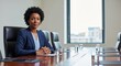 © Bhugol - A confident African American businesswoman sitting at a conference table in a modern office
