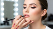 © jayshree - Makeup artist applying lipstick on woman lips during beauty salon cosmetic session professional makeup beauty treatment elegant female portrait