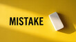© Rahman - Yellow background with mistake text and eraser concept showing error correction and learning from mistakes
