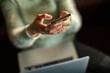 © Davor - Person texting on smartphone while working on laptop at home
