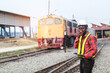 © arrowsmith2 - African Railway Engineer Using Walkie-Talkie and Tablet at Train Depot
